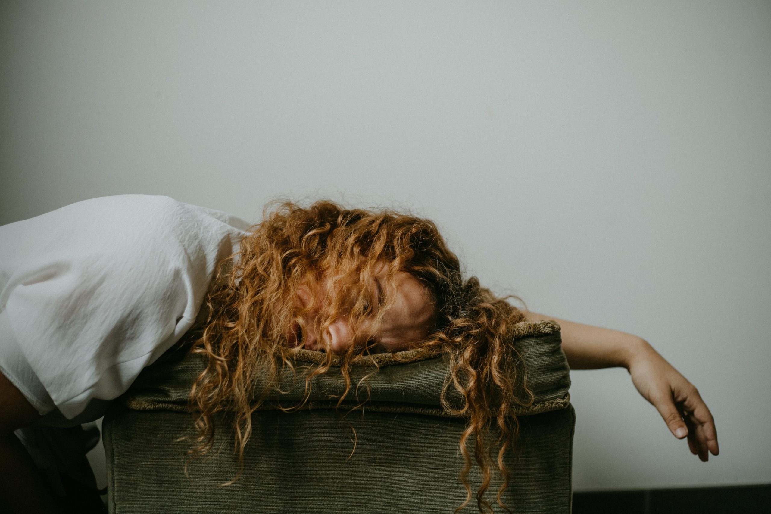 woman laying with left arm outstretched looking exhausted